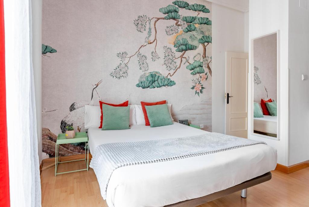 马德里Smartr Madrid Gran Via 47的卧室配有带绿色枕头的白色床