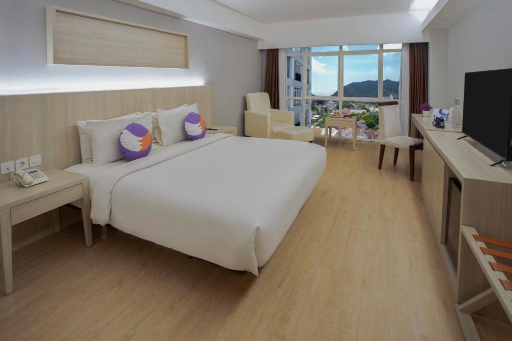 哥伦打洛省FOX Hotel Gorontalo的卧室配有一张白色大床和电视。