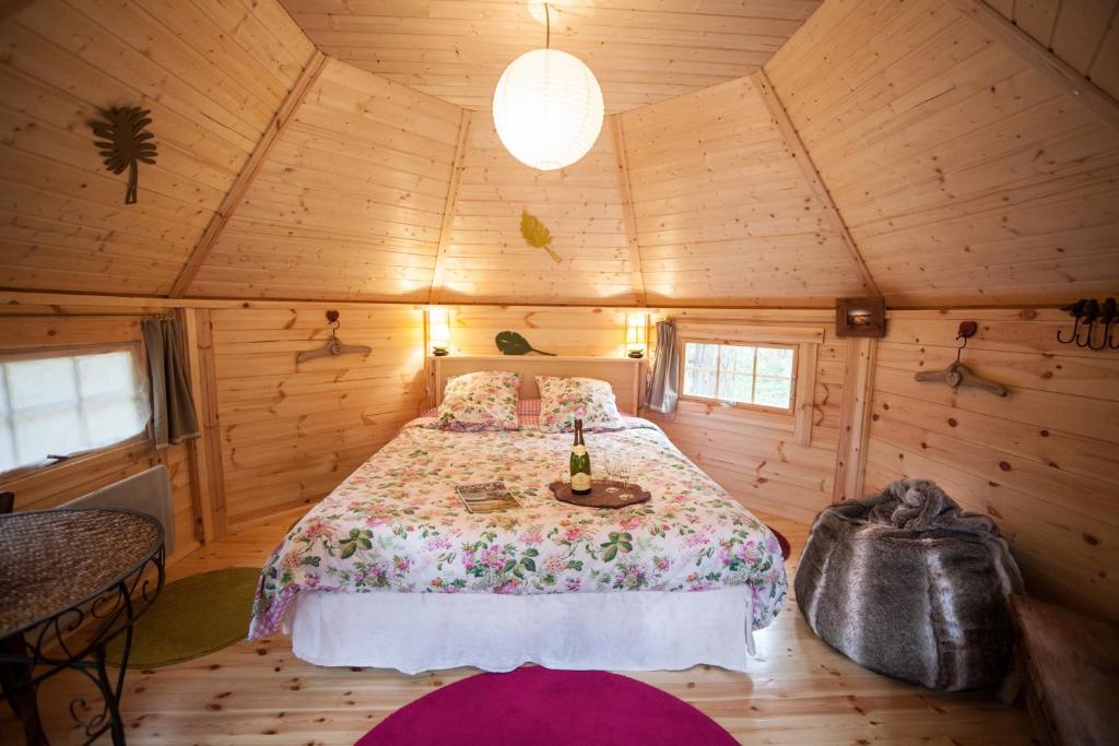 LapteLa Roche aux Fées的小木屋内一间卧室,配有一张床