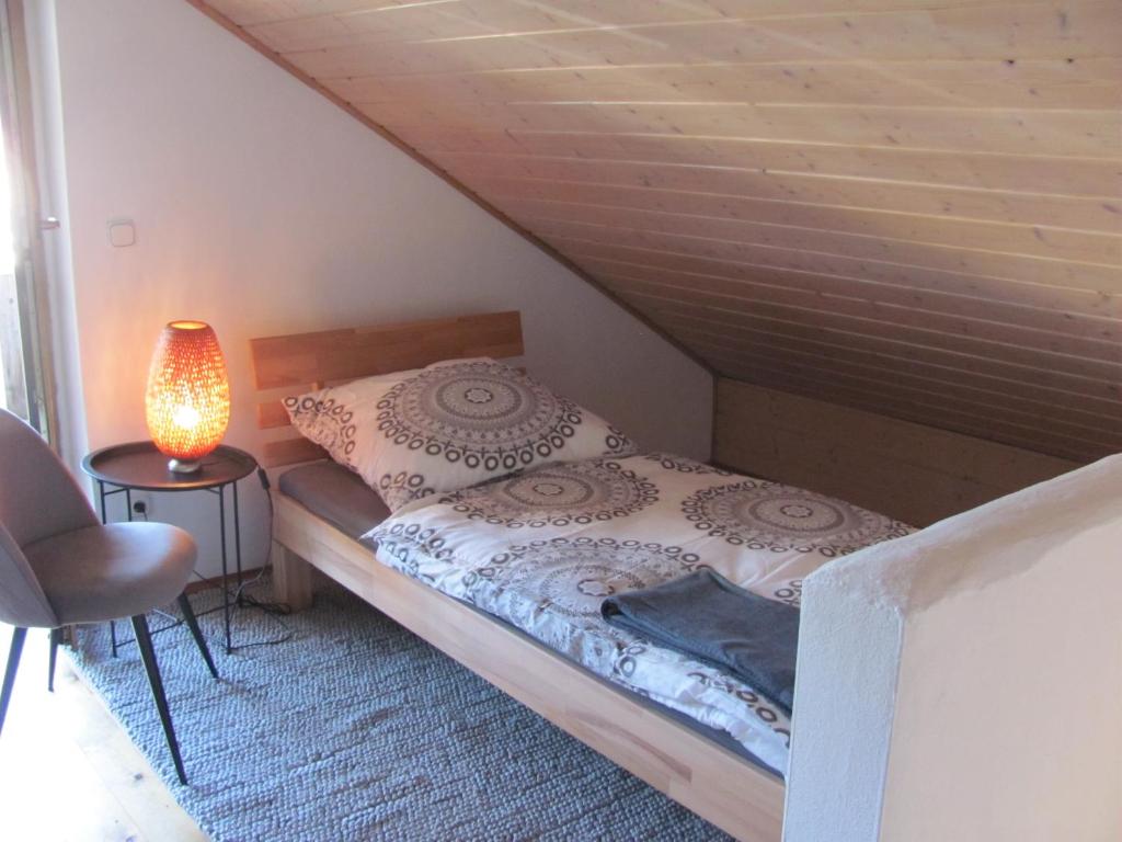 Trunkelsberg#4 Dachstudiozimmer mit 2 Betten und Balkon mit WG Bad Airport nah freies W-Lan的卧室配有一张床和一盏灯,位于地板上