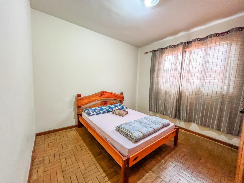 卡兰卡斯Ótima casa no centro de Carrancas的一间卧室设有一张床和一个窗口