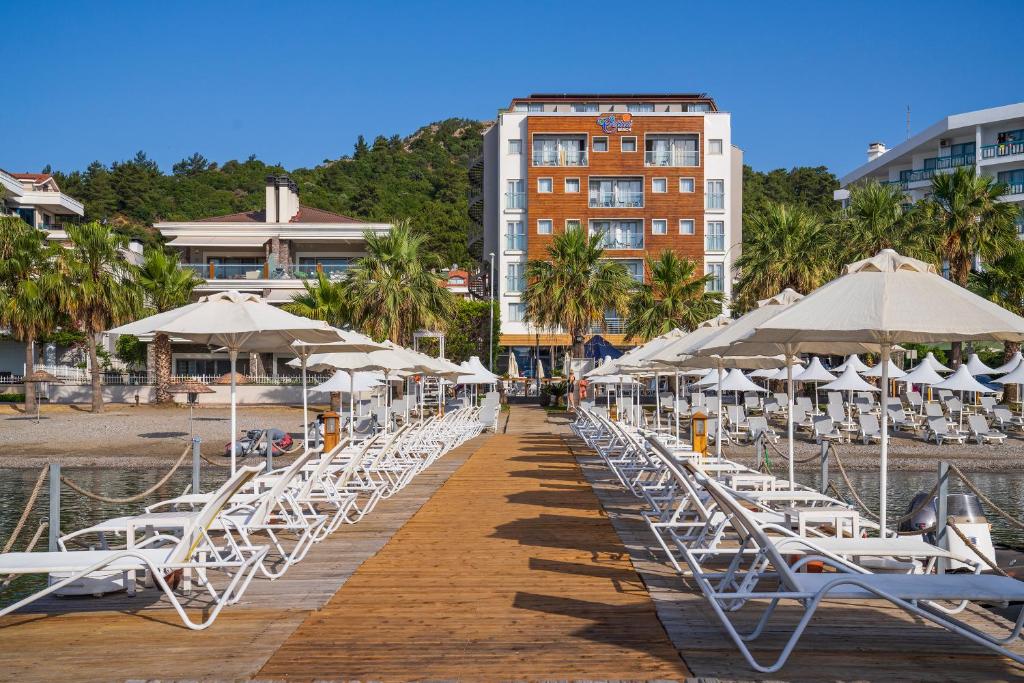 马尔马里斯塞提雅海滩度假酒店的码头上的一排椅子和遮阳伞