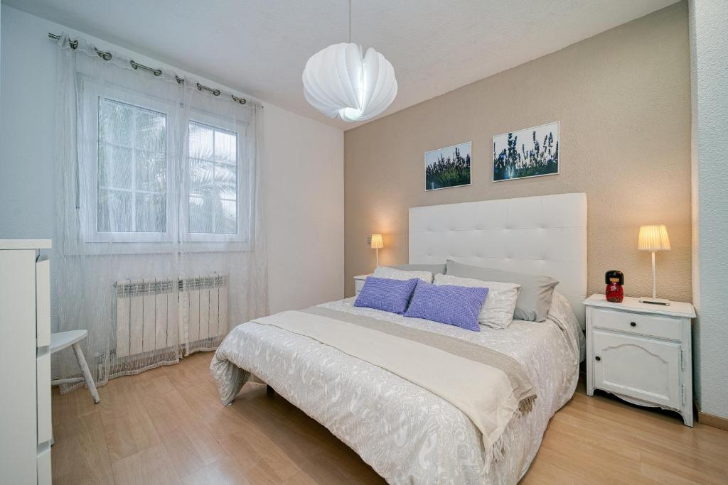 马德里SUKI HOUSE Chalet 1的一间卧室配有一张带蓝色枕头的大床