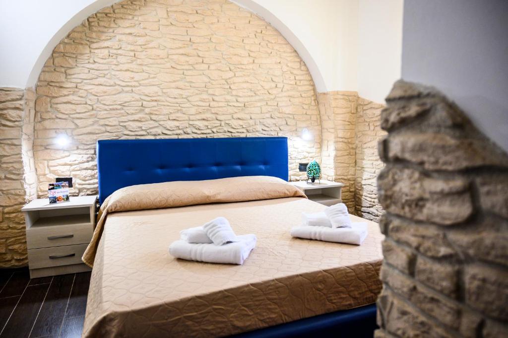 托雷拉皮罗Risa Apulia的一间卧室配有一张床,上面有两条毛巾