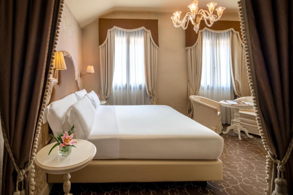 威尼斯Residenza Venezia | UNA Esperienze的卧室配有白色的床和镜子
