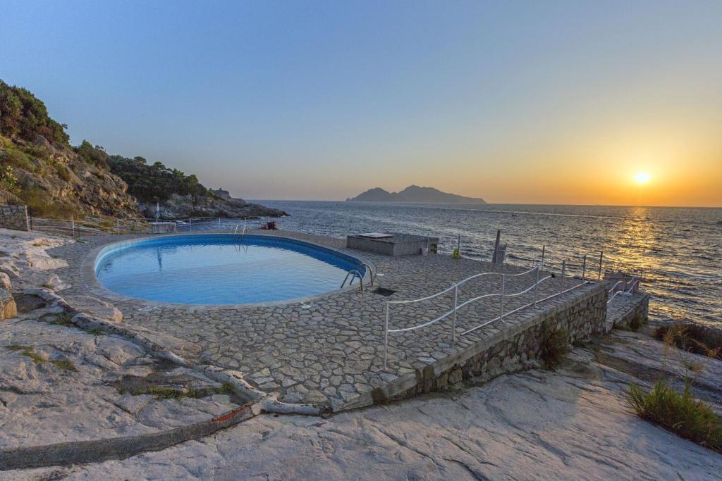 马萨鲁布朗斯AMORE RENTALS - Villa Domus Franca的日落时在海滩上的游泳池