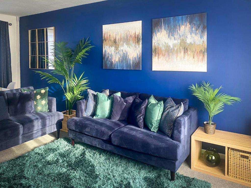卢顿Phoenix House - 2 Double Bedroom House - Business and Corporate Travellers的客厅配有紫色沙发和蓝色的墙壁