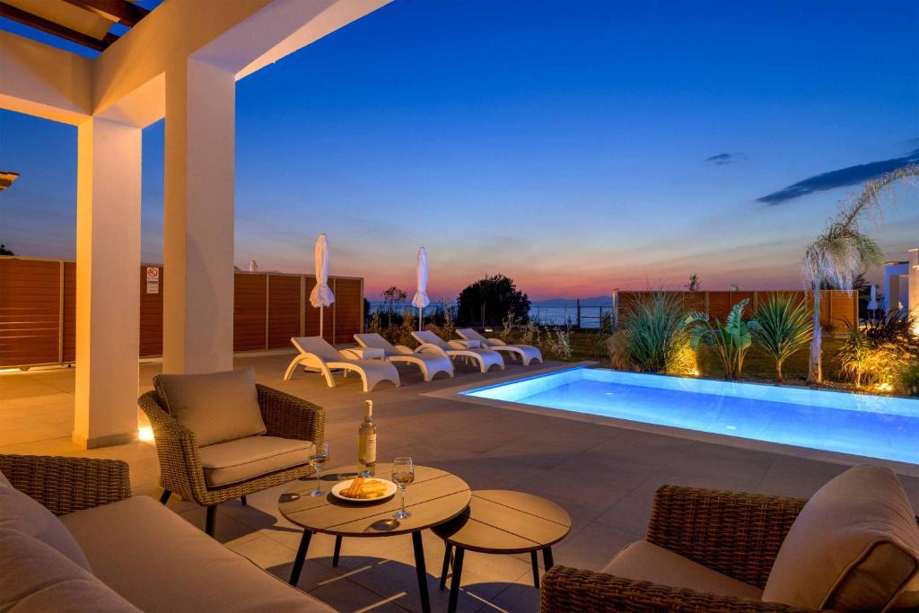 塞奥洛戈斯Villa Panaxia Kohille的一个带椅子的庭院和夜间游泳池
