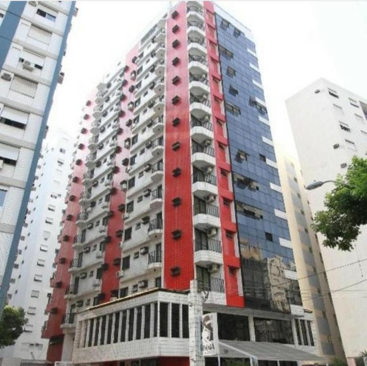 桑托斯Gonzaga Flat的一座高大的红色建筑,旁边设有阳台