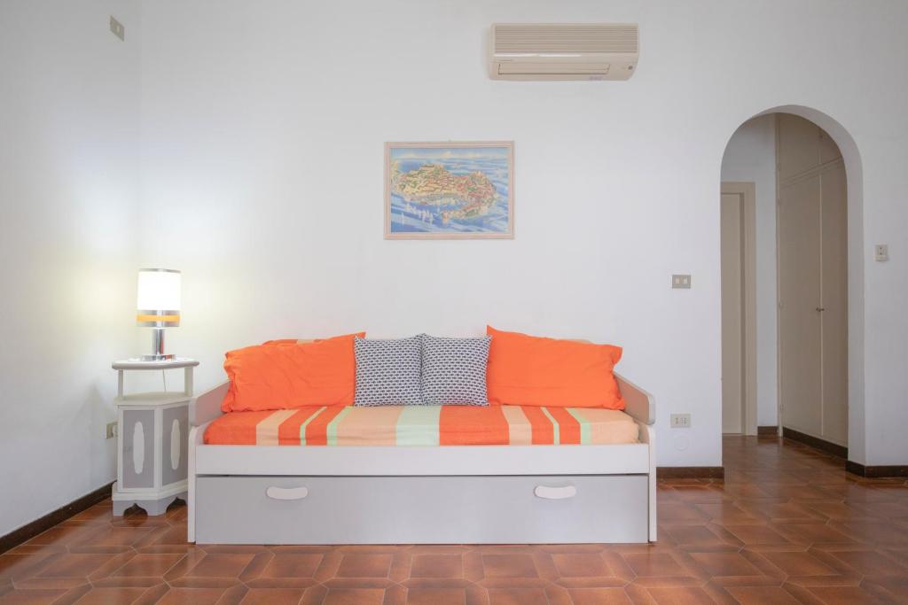 普罗基奥La Casetta di Procchio by HelloElba的一张带橙色和灰色枕头的床