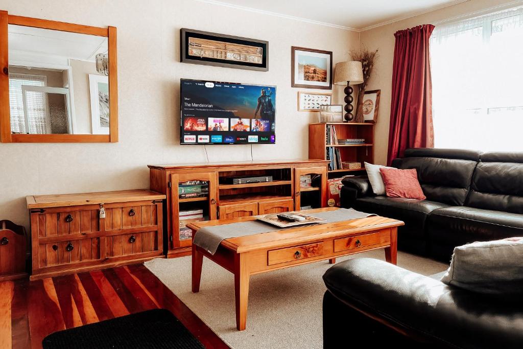 图朗伊Alpine House Tongariro - Turangi Holiday Home的客厅配有沙发和桌子