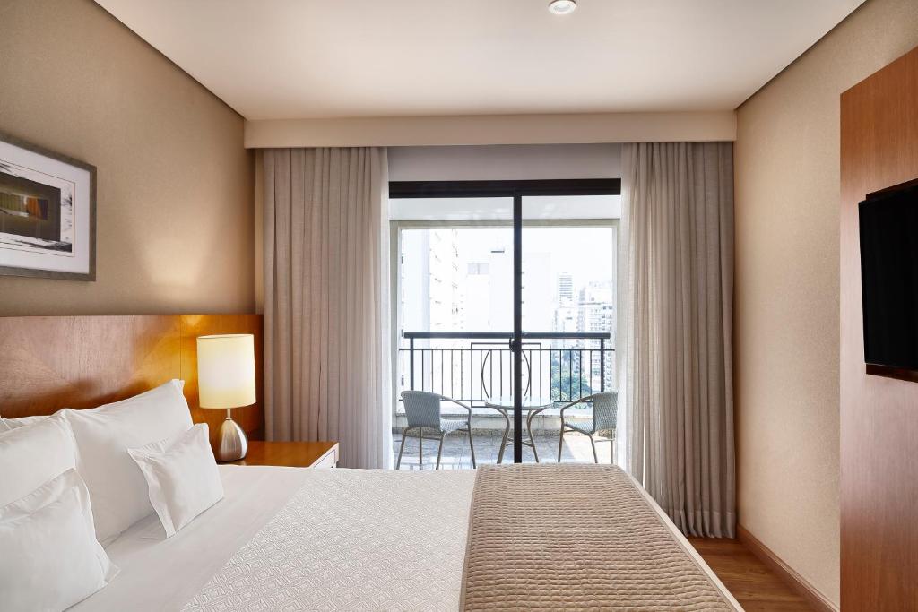 圣保罗George V Casa Branca的酒店客房设有一张床和一个阳台。