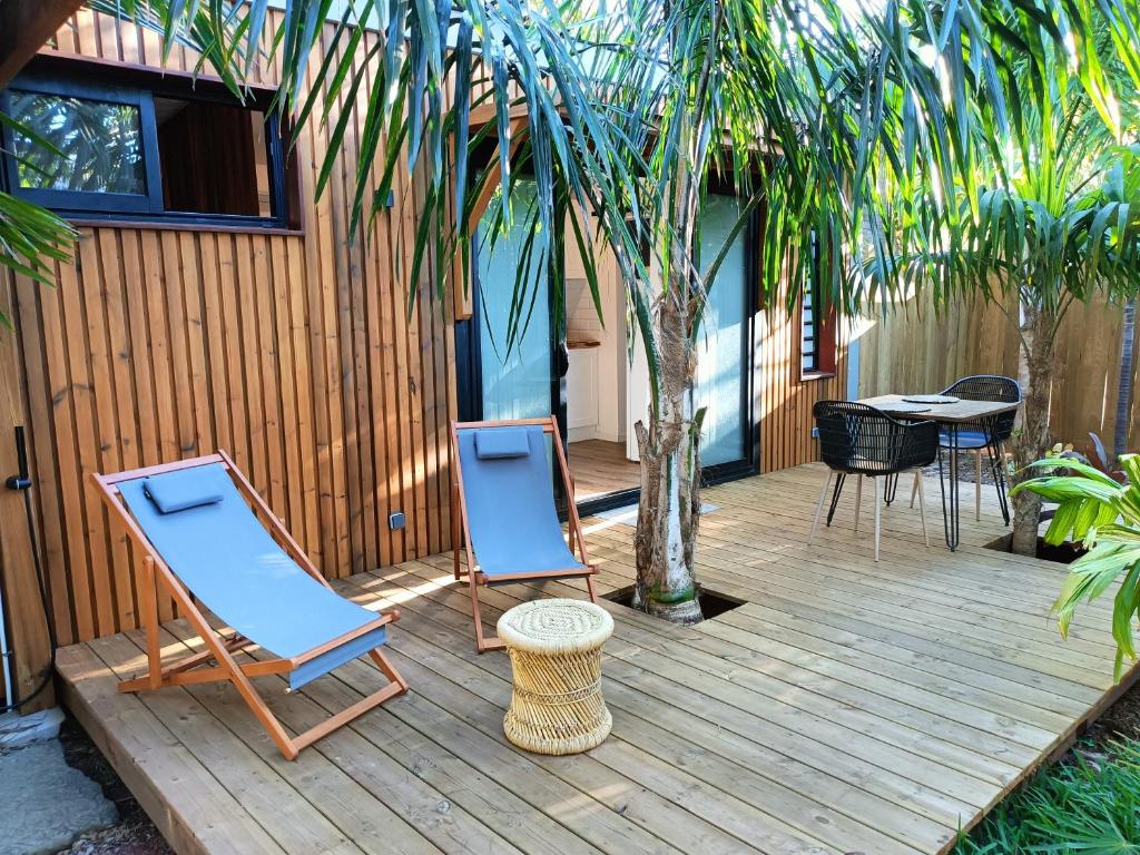 圣保罗Tiny house au lagon的木甲板上配有两把椅子和一张桌子