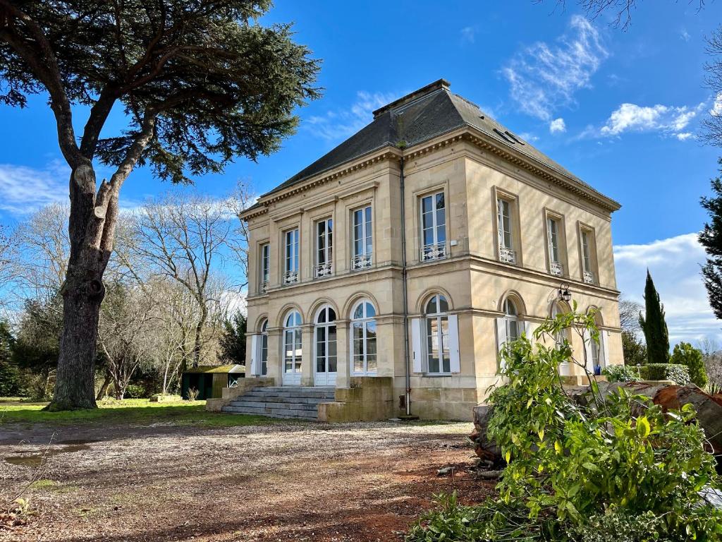 奥登河畔的布雷特维尔Superbe Maison de maître 10 chambres 300 m2 Caen的前面有一棵树的老房子