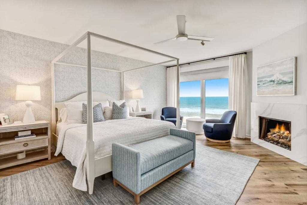 阿米莉亚岛Elegant Oceanfront Penthouse with Panoramic view, Omni Resort, Sea Dunes的一间卧室设有一张天蓬床和一个壁炉