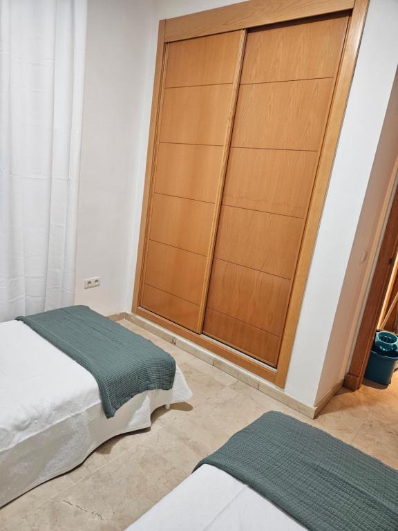 贝纳尔马德纳Arenal golf Sun & golf的一间卧室配有一张床和一个木制衣柜