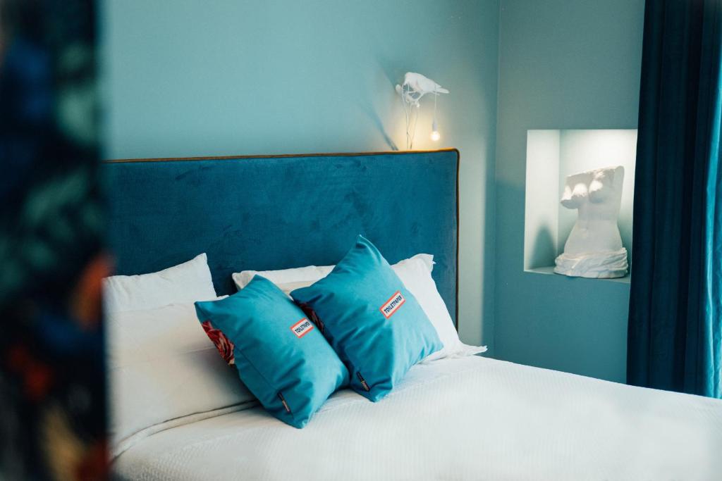 佩斯卡拉Aron Only Suites Bed and Breakfast的一张带蓝色和白色枕头的床