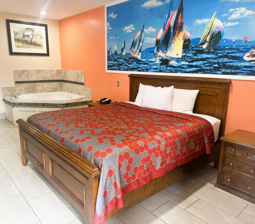 圣安东尼奥Pecan Valley Inn & Suites的一间卧室配有一张床、一个浴缸和一个浴缸