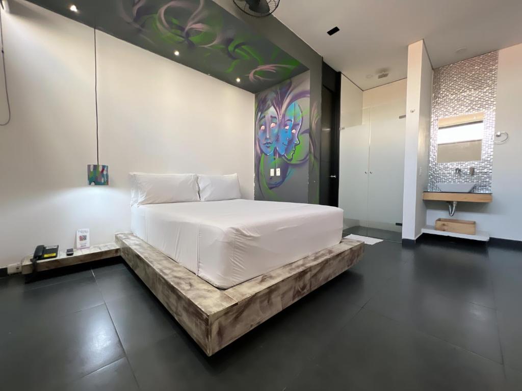 麦德林Hotel Medellin Art的卧室配有白色的床和墙上的绘画作品