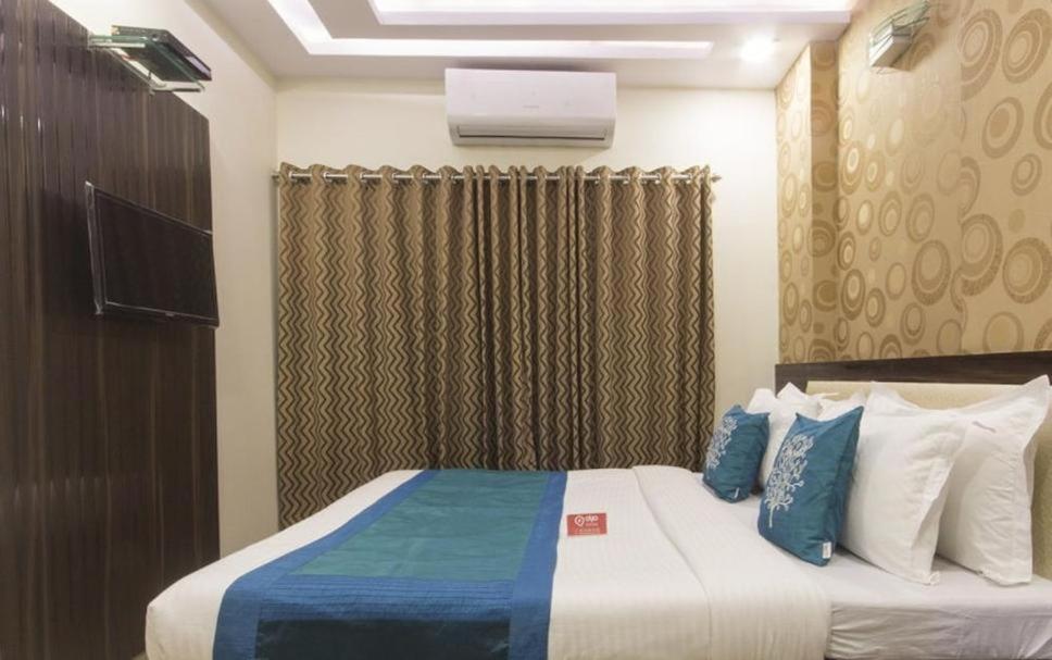 纳威孟买New Bramharaj By Glitz Hotels的一间卧室配有一张带蓝色和白色枕头的床