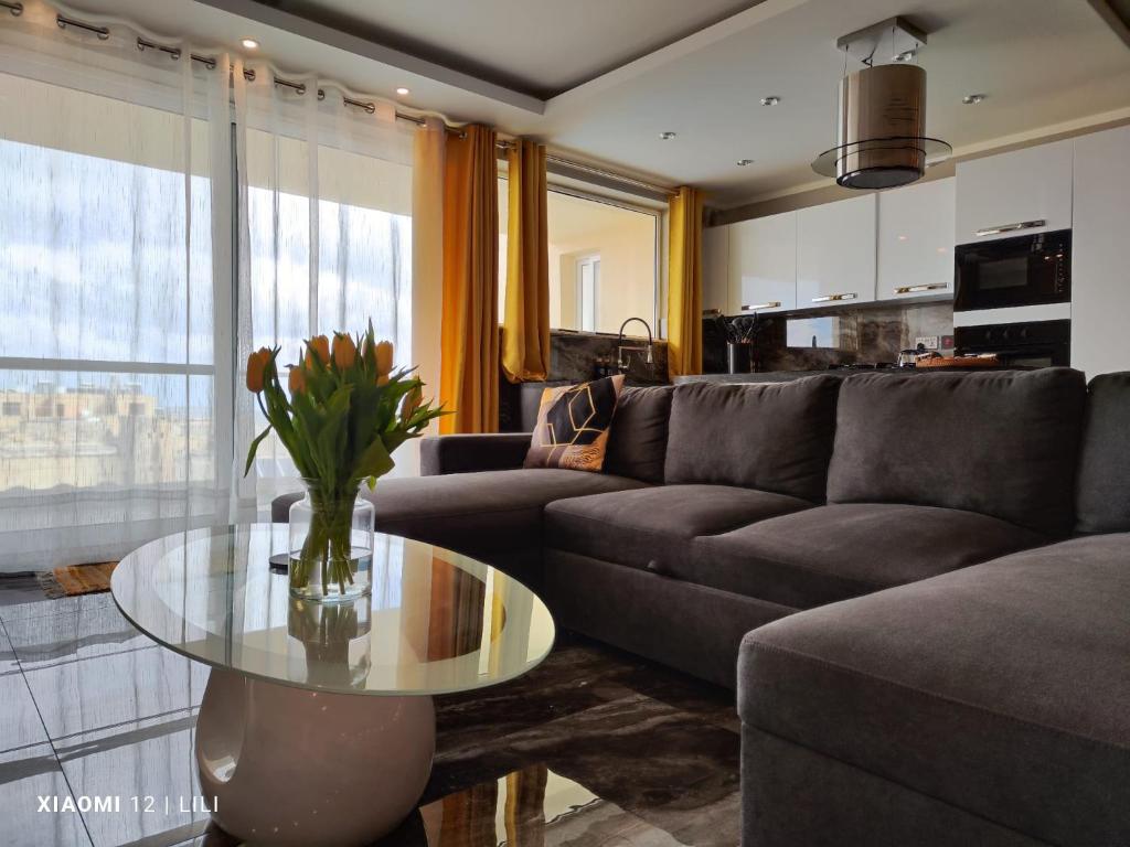 萨奈特Luxury Sanap Heights apartment with communal pool的带沙发和玻璃桌的客厅
