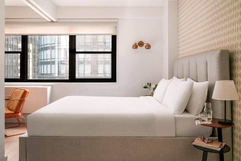 纽约Sonder at The Nash的卧室设有白色大床和窗户。