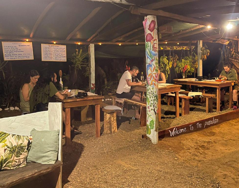德雷克Rio Agujitas Eco-Jungle的一群人坐在帐篷里的桌子上