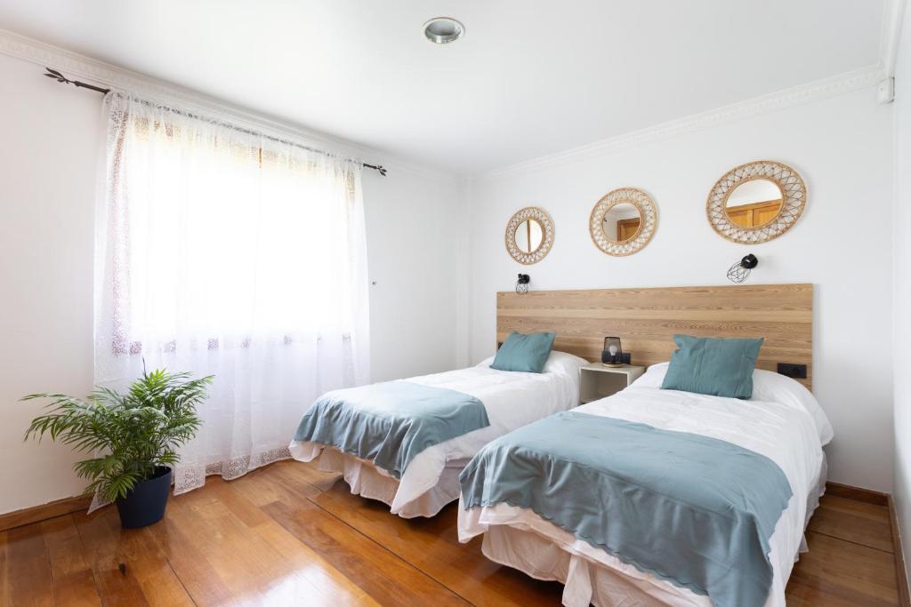 拉拉古纳Casa Lali Habitación 2的卧室设有两张床,拥有白色的墙壁和木地板