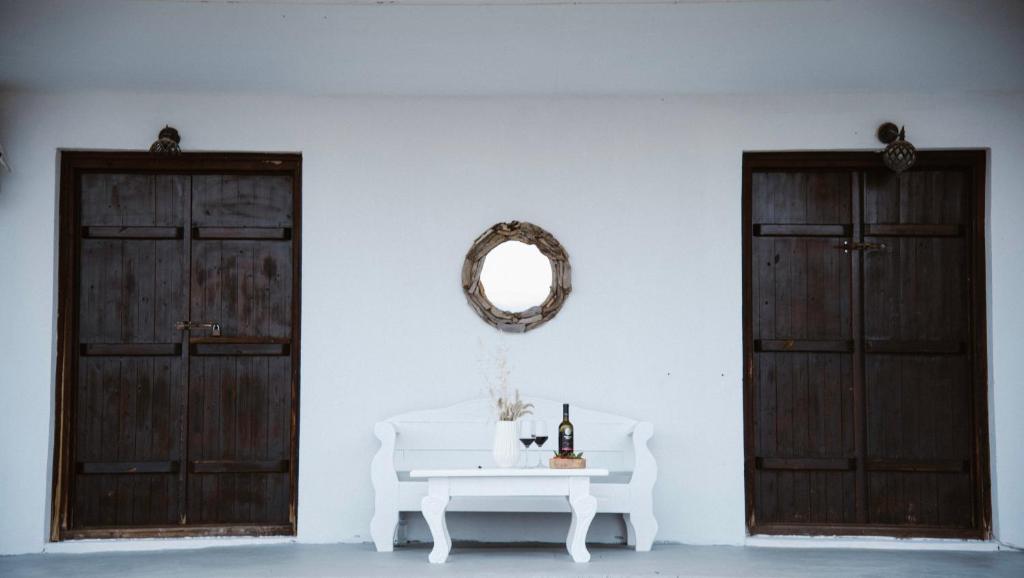 阿莫利亚尼岛Villas Gemeli的白色的房间,设有两扇门和一张带镜子的桌子