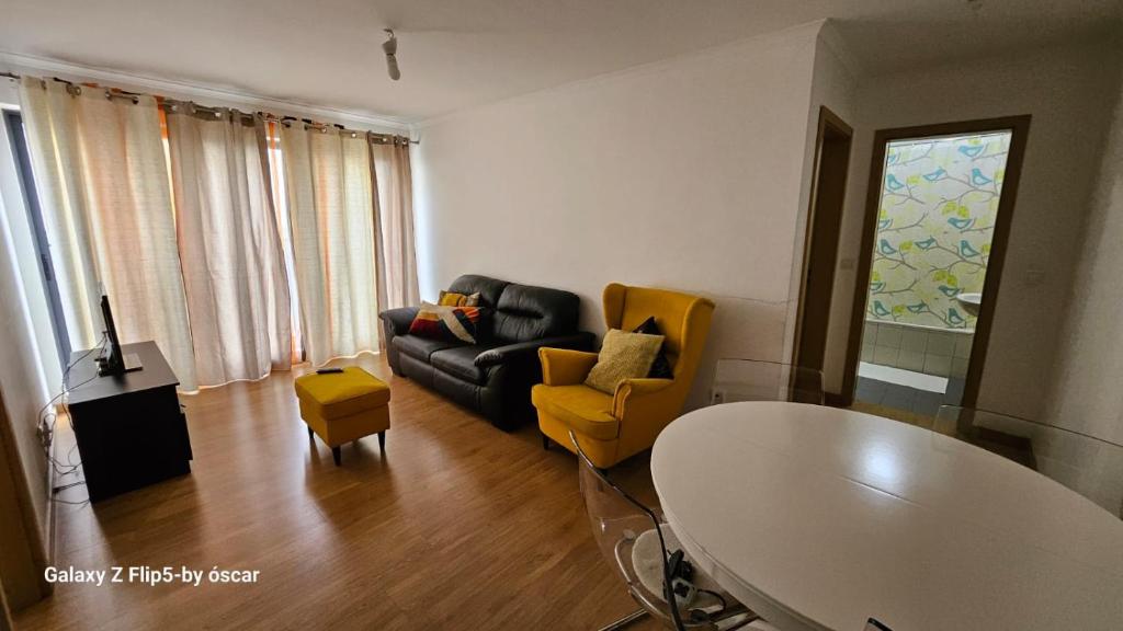 奥迪韦拉什Ap Central Chic的客厅配有黑色沙发和黄色椅子
