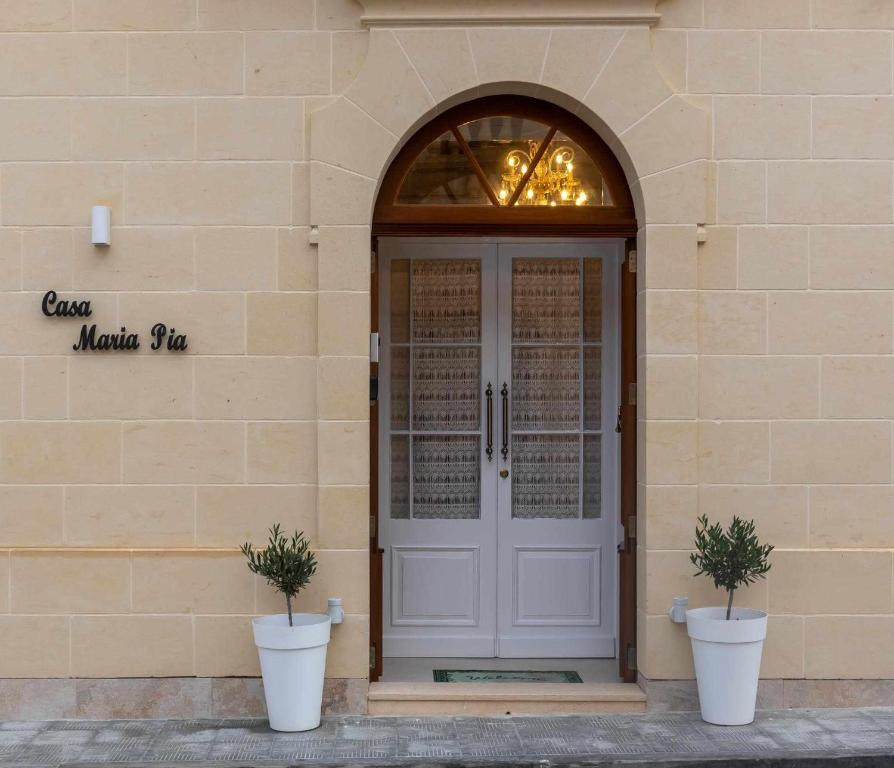 纳杜尔Casa Maria Pia的两棵盆栽植物的建筑物的前门