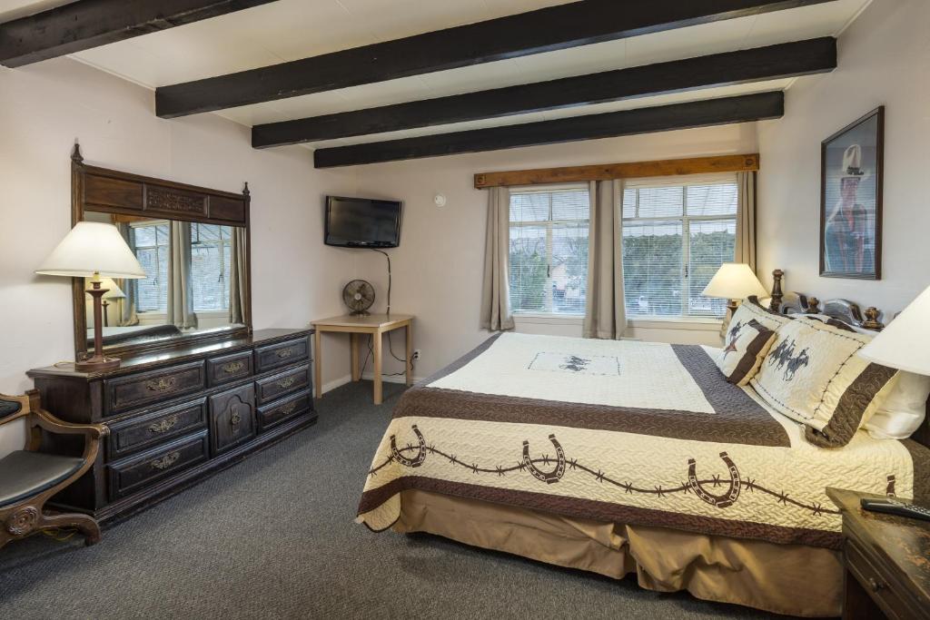 摩押Apache Motel的一间卧室配有一张大床和电视