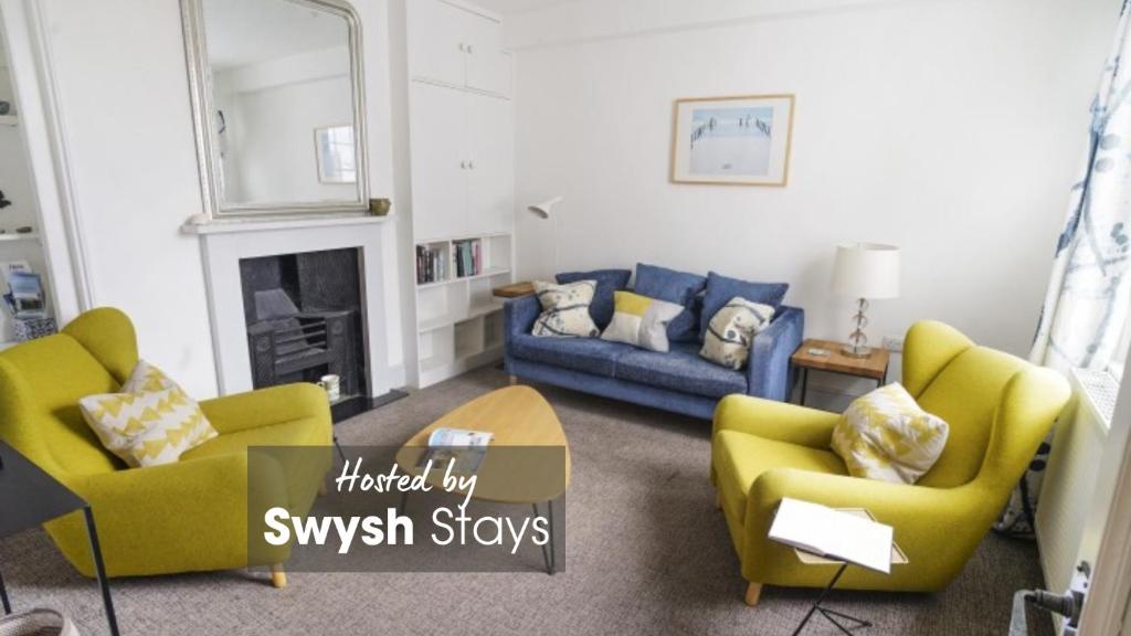 考斯Paskins, Cowes - Sleeps 4 - 2 Bed - 2 Bath - Central Location的客厅配有黄色椅子和蓝色沙发