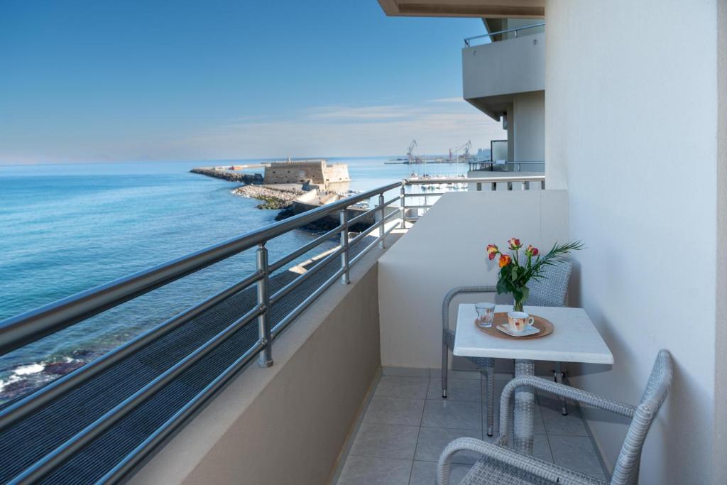 海若克利欧克洛诺斯酒店的阳台配有桌子,享有海景。