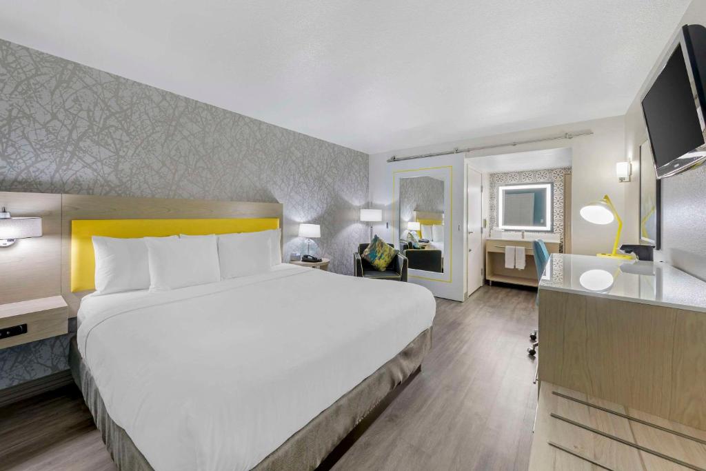 图莱里Hillstone Inn Tulare, Ascend Hotel Collection的酒店客房设有一张大床和一张书桌。