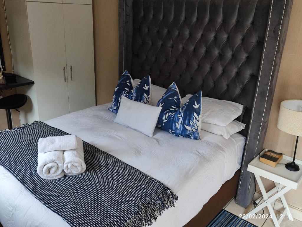 RandburgOnyx Luxury cottage的一张带蓝色和白色枕头的床以及毛巾
