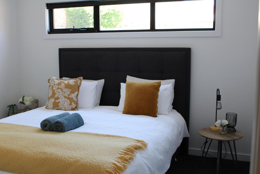 朗塞斯顿CBD Elizabeth St Modern Townhouse - Secure Parking的一间卧室配有一张带黑色床头板和枕头的床。