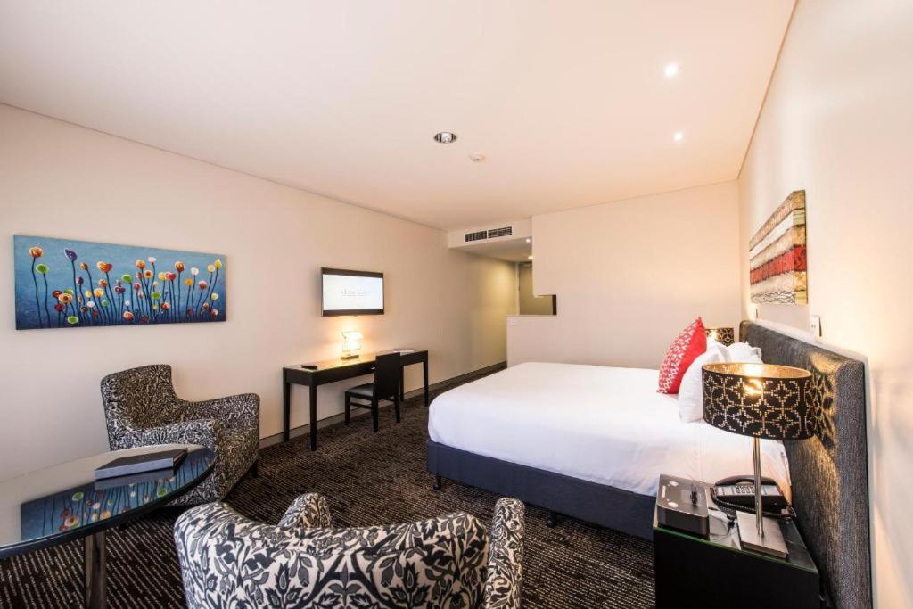 布里斯班卡拉姆维尔套房和会议中心酒店的配有一张床和一张书桌的酒店客房