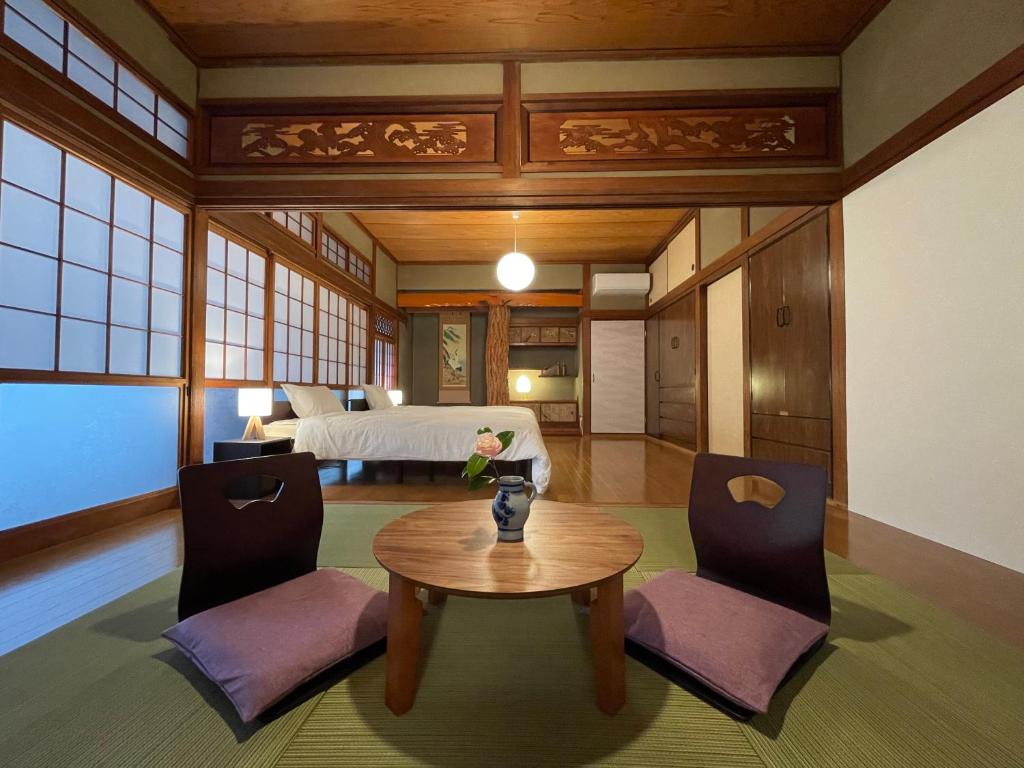 宫崎貸切宿KUMANO的配有桌椅和床的房间