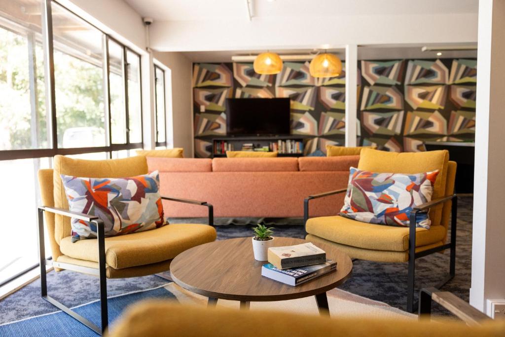 皇后镇Haka House Queenstown Lakefront的客厅配有沙发、两把椅子和一张桌子
