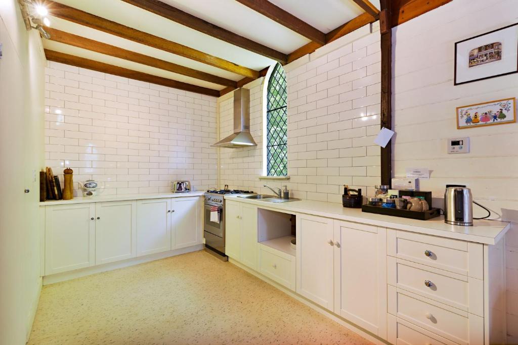 比奇沃斯Blue Gum Church的一间设有白色橱柜和窗户的大厨房
