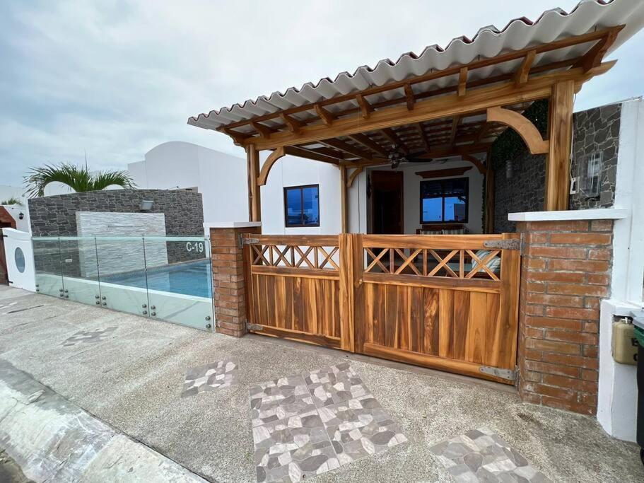 萨利纳斯Casa con piscina Punta Carnero的一座带木门和围栏的房子