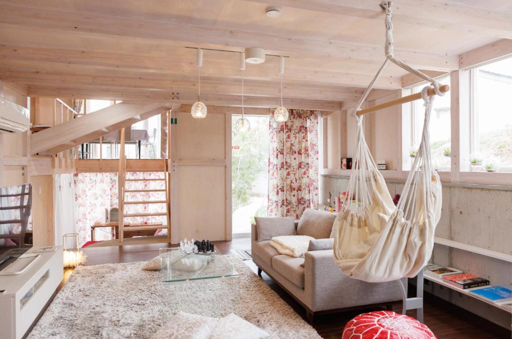 富山Platina Luxe House的客厅设有吊床,天花板上挂着吊床