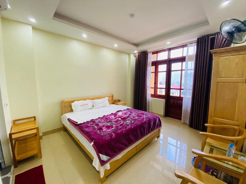 Bản PiênKim Thoa Hotel Trung Khanh的一间卧室配有一张带紫色毯子的床