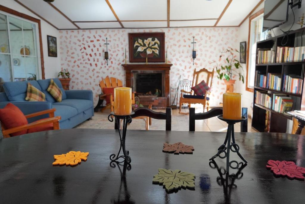 ApanecaEl paraíso de Apaneca的客厅配有一张桌子和两把蜡烛
