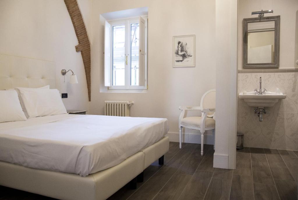 佛罗伦萨托纳伯尼景住宿加早餐旅馆的白色卧室设有床铺和水槽