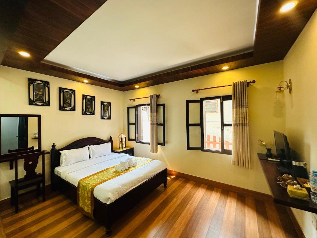 琅勃拉邦Villa Ban Pakham Hotel的一间卧室设有一张床和两个窗户。