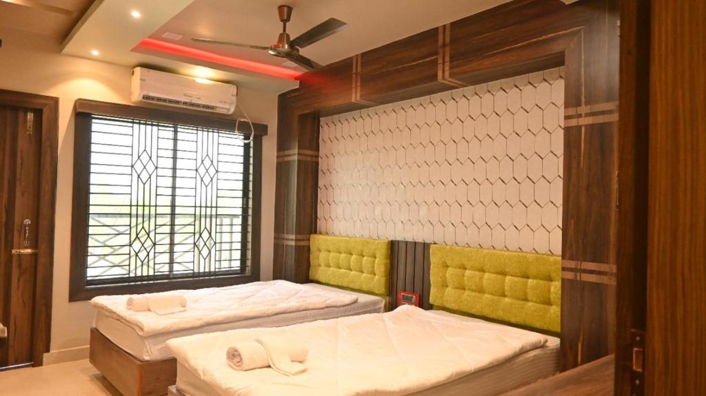SonāmuraHotel Maisha International的客房设有两张床和窗户。