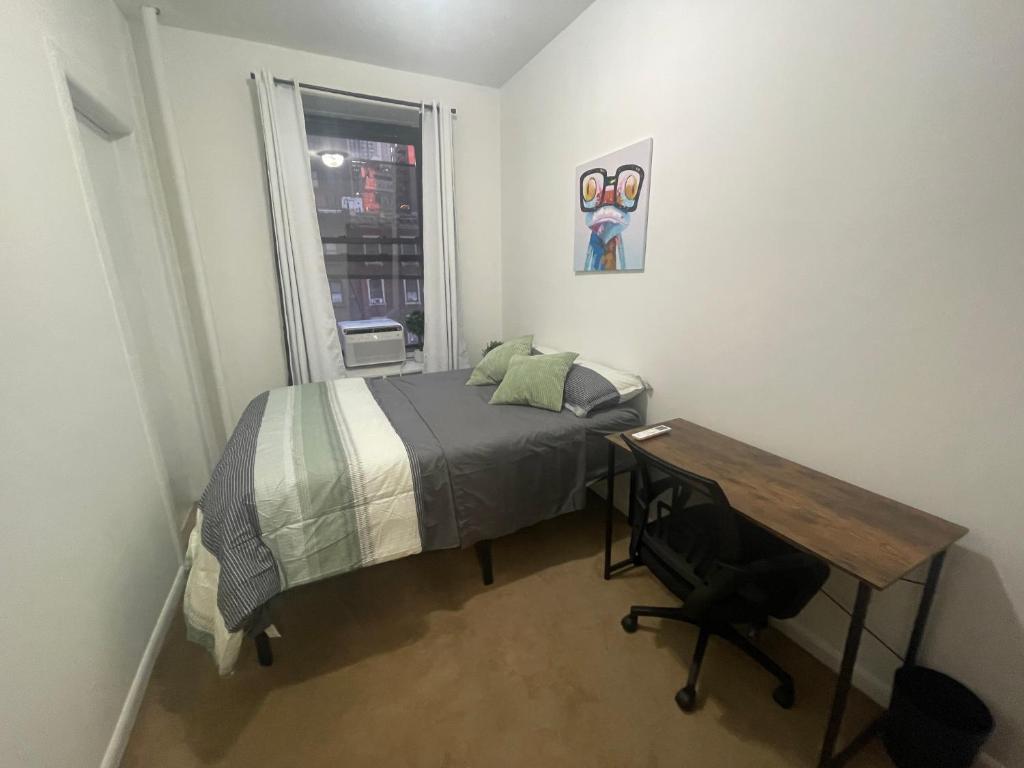 纽约Comfy Guest House by Columbus Circle的一间卧室配有一张床、一张书桌和一个窗户。