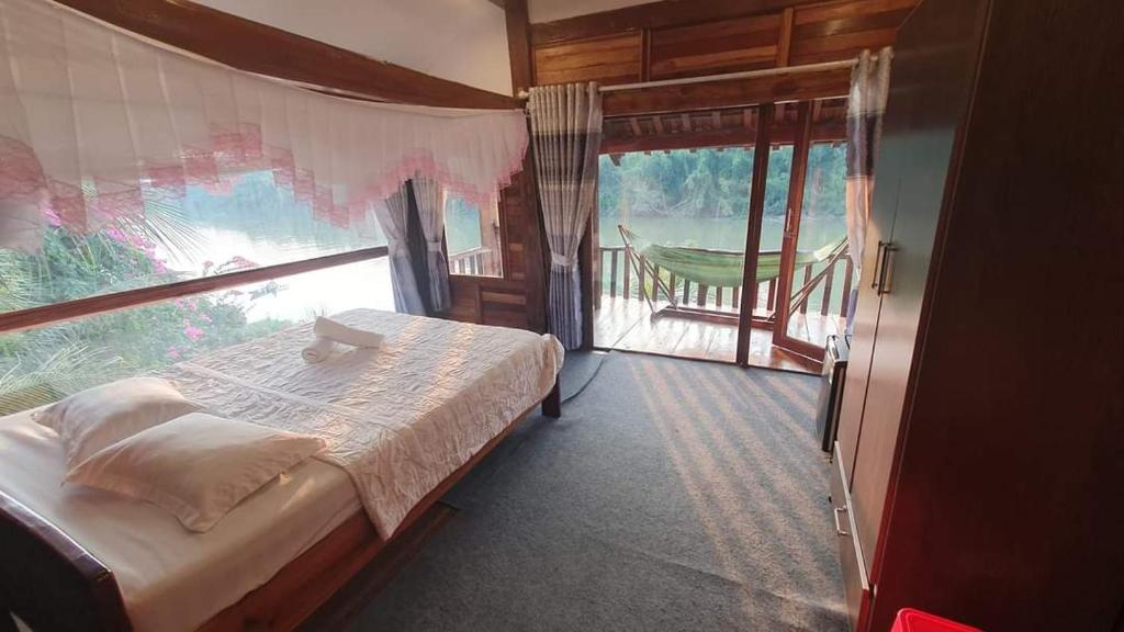 吉仙绿竹苑度假村的一间卧室设有一张床和一个大窗户